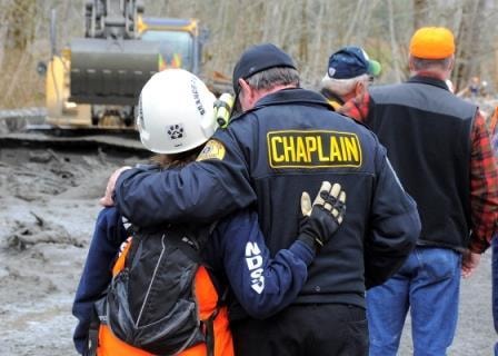Chaplain comforting a first responder at an emergency scene