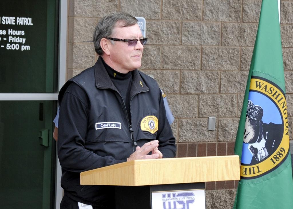 Mike Neil speaking at WSP podium with Washington State flag