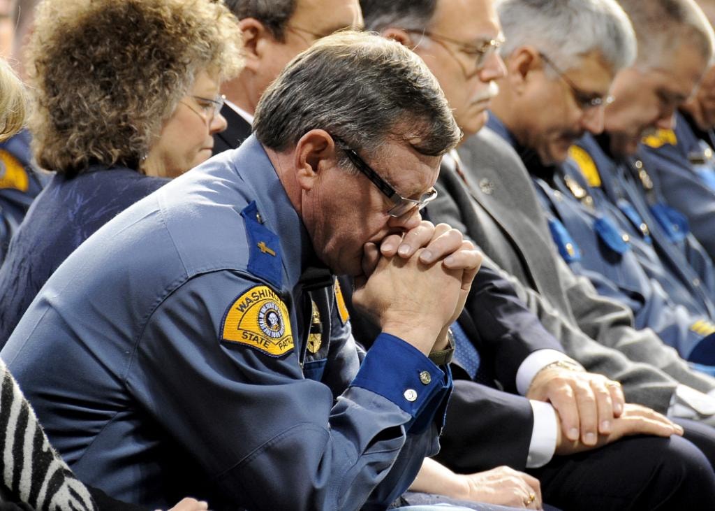 Mike Neil in Washington State Patrol uniform, bowed in prayer