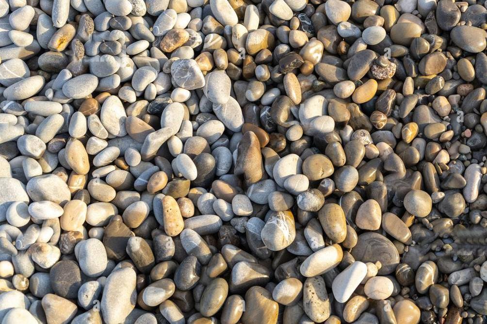 Countless smooth pebbles on a beach — illustrating the miracle of finding one specific rock