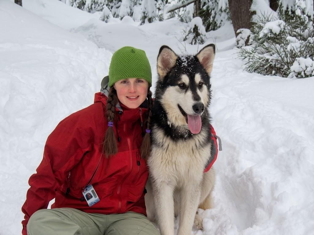 Susanne with her husky in a snowy mountain setting